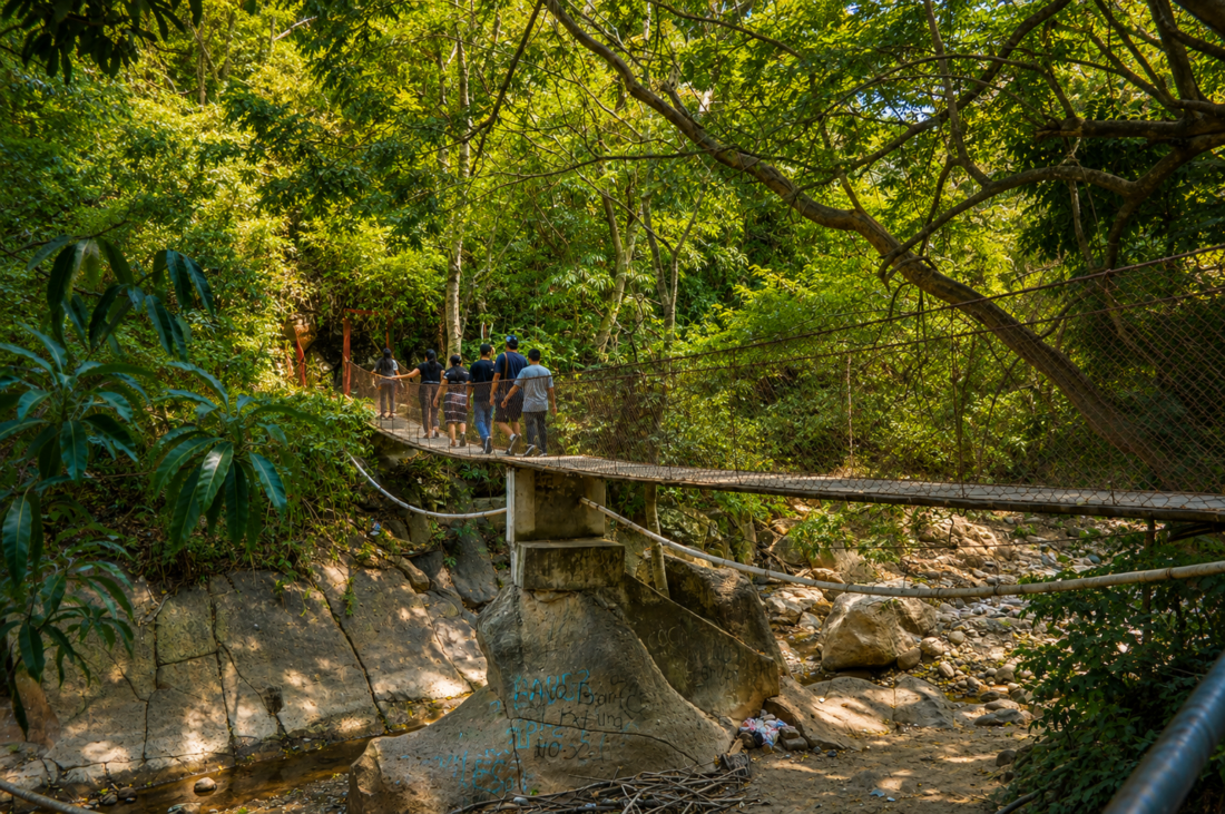 Personas disfrutando de un río con pozas naturales en un entorno campestre